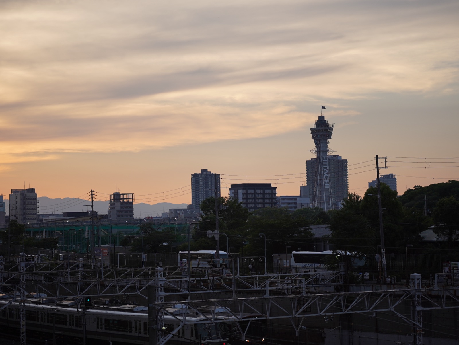 City tower and railway tracks beneath a sunset sky before