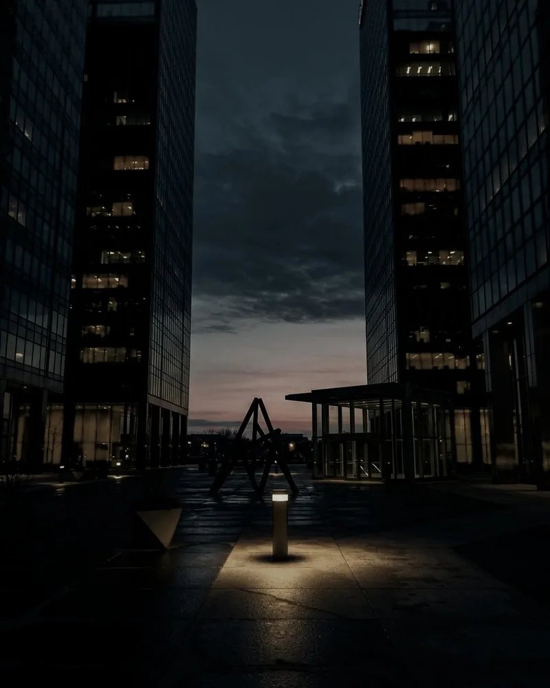 A city tower and railway tracks beneath a sunset sky.